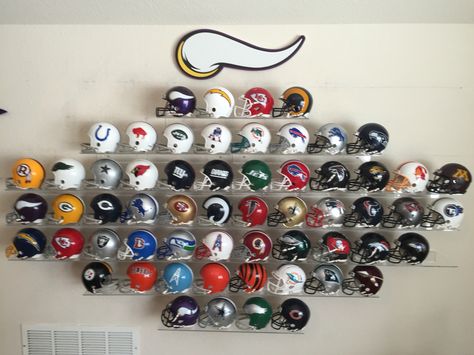 Man cave wall. These are the mini helmets--5 inches tall. Initial goal was four helmets--Vikings, Packers, Bears, Lions. Then things got out of control.   Football helmets display Football Room Man Caves, Mini Football Helmet Display, Football Helmet Display Ideas, Mini Helmet Display Ideas, Football Display Ideas, Display Case Ideas, Sports Memorabilia Display, Football Man Cave, Helmet Display