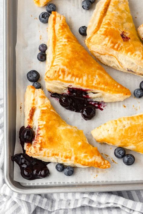 Blueberry turnovers on a sheet pan. Recipe Using Puff Pastry, Recipes Using Puff Pastry, Blueberry Turnovers, Using Puff Pastry, Cherry Turnovers, Phyllo Recipes, Blueberry Filling, Puff Pastry Recipe, Canned Blueberries