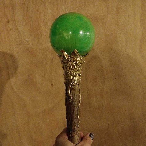 This DIY maleficent staff was made with a branch I cut from my yard, hot glue, gold spray paint, green paint, and a dollar store plastic ornament. I'll be able to place a glow stick in the inside and then hot glue to finish! The hot glue is good enough to hold for walking, but is easy enough to pry off if I want to use it again with a new glow stick. Glowing Staff Diy, Diy Magic Staff, Maleficent Staff Diy, Diy Party Costumes, Maleficent Staff, Staff Diy, Maleficent Costume Diy, Maleficent Halloween Costume, Maleficent Halloween