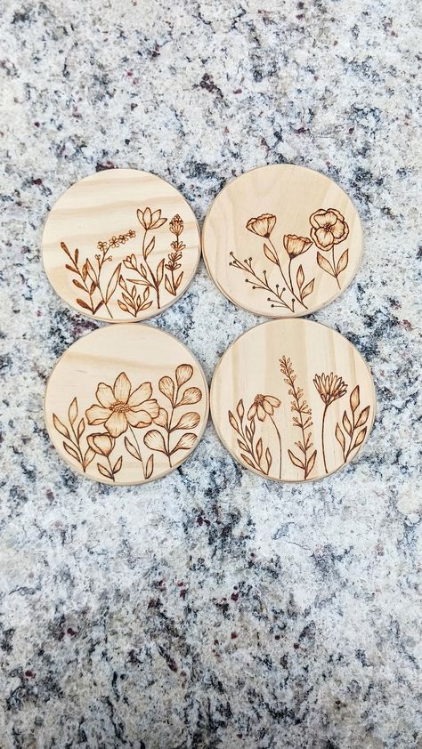 This is a 4 inch round, wood burned wildflower themed coaster set. This set contains different wildflowers burned onto them. These are hand-burned, then sealed with a clear matte polycrylic. They have a cork backing to prevent scratching. The thickness of each coaster is 1/4 inch. Wood Burned Flowers Simple, Burn Pen Ideas, Wooden Engraved Coasters, Wood Making Ideas, Wood Coasters Ideas, Cricut Wood Burning, Wood Burned Sunflower, Wood Burning Flower Designs, Wood Burning Ideas Flowers