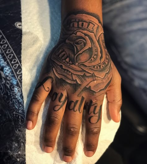 Men’s Hand Tattoos Writing, Money Rose Tattoo On Hand, Money Rose Hand Tattoo Men, Loyalty Hand Tattoos For Guys, Hand And Wrist Tattoos For Guys, Trap Tattoos Men Hand, Money Rose Tattoo For Men, Loyalty Over Love Tattoo For Men, Loyalty Tattoo For Men