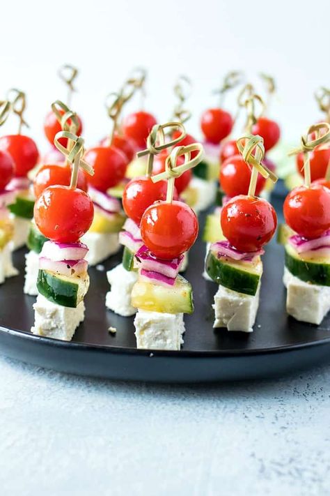 Greek Salad Skewers - Cherry tomatoes, cucumber, and red onion are tossed in a homemade Greek vinaigrette and layered on mini skewers with a little square of feta cheese. Christmas Appies, Mini Skewers, Simple Greek Salad, Tomato Skewers, Salad Skewers, Greek Vinaigrette, Gluten Free Puff Pastry, Skewer Appetizers, Oh Sweet Basil