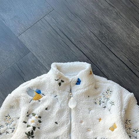 YITAI on Instagram: "I drew inspiration from the intricate patterns of traditional Chinese silk embroidery, renowned for its botanical graphics featuring birds and flowers. I incorporated these design elements onto a full-zip sherpa jacket, creating a piece that highlights delicate and graceful bird motifs, complemented by the serene descent of flowering blooms. Finished with a leaf zipper of course." Chinese Silk Embroidery, Flower Jacket, Monogram Jacket, Birds Embroidery Designs, Chinese Embroidery, Fluffy Jacket, Chinese Silk, Bird Motif, Birds And Flowers