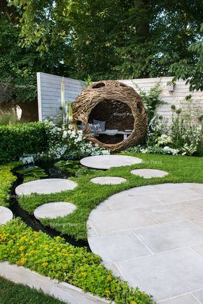 woven willow bird hide (willow sculpture) and concrete circular slabs as a path over a pond surrounded by Chamaemelum nobile (chamomile lawn), Eryngium giganteum, Eremurus himalaicus Garden Retreat Ideas, Chamomile Lawn, نباتات منزلية, Have Inspiration, Garden Landscape Design, Garden Care, Camping Ideas, Outdoor Planters, Small Gardens