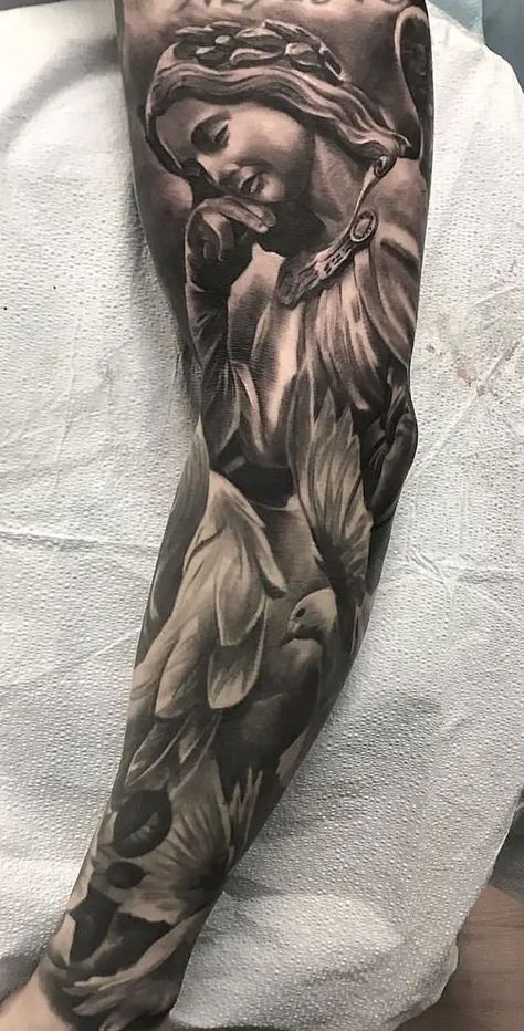 Top 50 Popular Tattoos with Meanings & Designs | 2023 European Tattoos Traditional, Tattoo Ideas For Men Bicep, Angel Tats, Inner Bicep Tattoo Ideas, Realism Tattoo Sleeve, Bicep Tattoo Ideas, Jesus Tattoo Sleeve, Religious Tattoo Sleeves, Angel Sleeve Tattoo