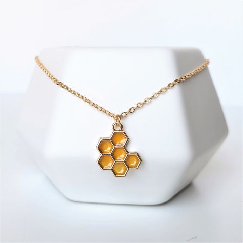 "A hexagonal honeycomb pendant with stunningly realistic honey enamel details on a dainty gold chain. Charm is 19mm tall, 16mm wide and chain is 2x2.5mm rolo style and shown as 16\" in photos. Other length options are available from the dropdown menu! If you would like a custom length, message me and I can make that for you :) Charm and chain are gold plated alloy. Jewelry Care Tips For a Long, Happy Life Together <3 * Store your jewelry in an air-tight container to avoid metal parts becoming ta Honeycomb Jewelry, Honey Jewelry, Honeycomb Necklace, Dainty Gold Chain, Schmuck Gold, Gold Pearl Jewelry, Jewelry Nature, Bee Jewelry, Nature Necklace