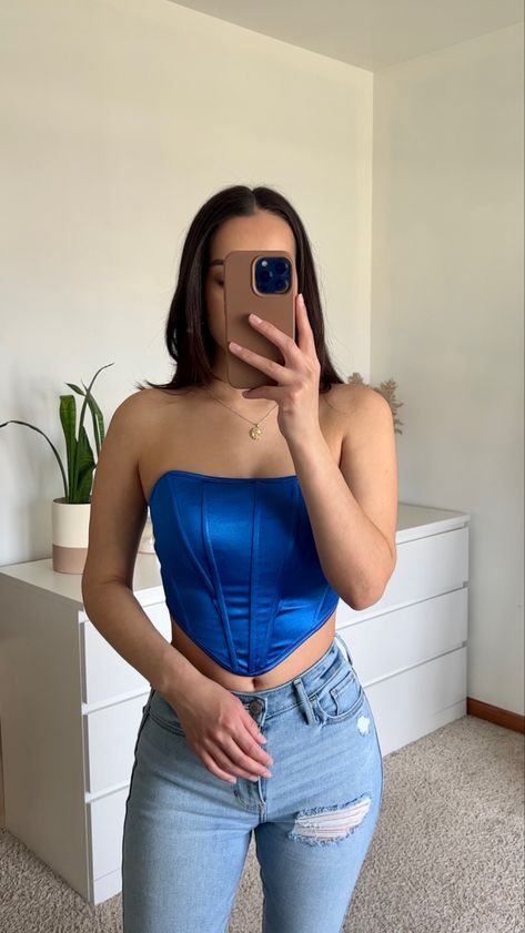 She is holding a iPhone 13 Pro in a brown phone case. While wearing a royal blue corset top, light wash blue jeans and a dainty gold Virgin Mary necklace . Amazon Corset, Amazon Corset Top, Corset Date Night Outfit, Blue Corset Top Outfit, How To Style A Corset, Blue Top Outfit, Corset And Jeans, Corset Top Outfit, Top Azul