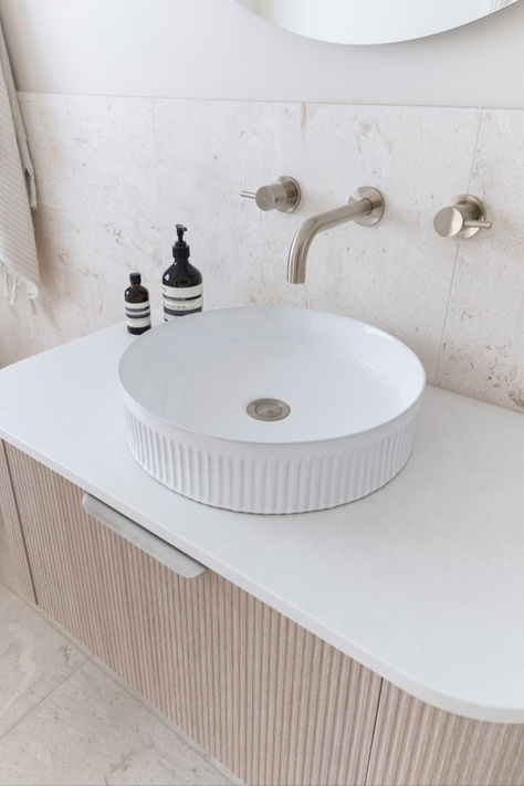 The soft palette, fluted details and natural textures fill the space with a calming ambience that we can’t get enough of. Featuring the Waverley vanity in Coastal Oak with Alabaster Cherry Pie Benchtop, Round Fluted Gloss White Basin, Bronte Gloss White Bath and Eclipse 700mm LED Mirror. Waverley Vanity, Ripples Bathrooms, Fluted Bath, Frosty Carrina Caesarstone, Curved Vanity, Bathroom Things, Coastal Oak, Coastal Interior, Soft Palette