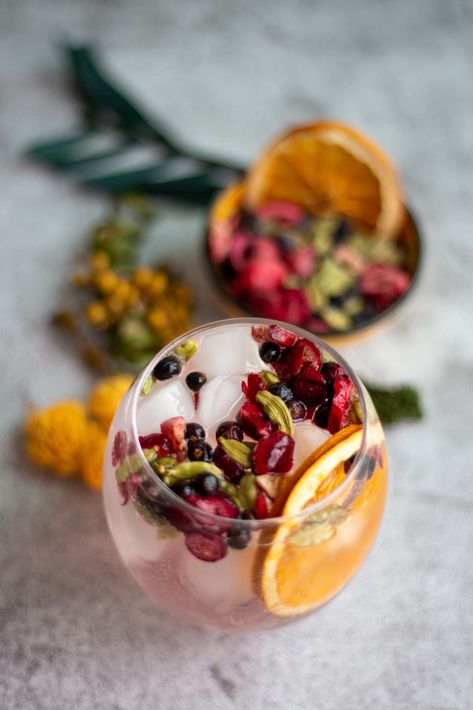 A short round glass of gin and tonic, also filled with ice, with garnishes, on a concrete looking ground and with blurry garnishes on the background. Dried Citrus Cocktail Garnish, Gin And Tonic Garnish, Dehydrated Lemons, Drink Essentials, Orange Garnish, Dehydrated Citrus, Drink Garnishes, Citrus Tea, Dried Citrus