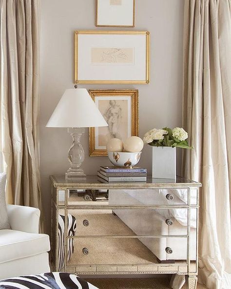 Elegant bedroom features stacked abstract nude sketches placed over a mirrored dresser topped with a crystal baluster lamp and a Nate Berkus Ikat Bowl flanked by windows dressed in champagne colored silk curtains. Mirrored Dresser, Nate Berkus, A Living Room, Zebra Print, Dresser, Curtains, Mirror, Living Room, Bedroom