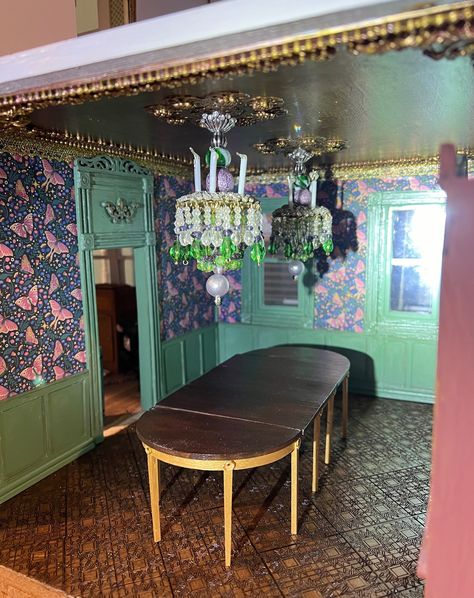 This is the dining room of the Catrina House. The chandeliers are not permanently installed yet. I really like how the two look hanging over the table. That shelf will be on that wall and it will be fun to decorate it. There will also be a buffet at the back, between the windows. I really like how it's all coming together! #miniatures #dollhouseminiatures #dollhouse #minis #minismakemehappy #12thscale #onetwelthscale #dollhousedecor #dollhousedecorating #miniatureartist Dollhouse Dining Room, Dollhouse Decorating, Miniature Things, The Dining Room, Dollhouse Decor, Diy Dollhouse, The Two, The Table, Chandeliers