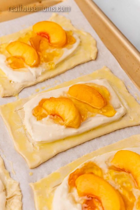 Peach Cream Cheese Danish is a delicious sweet treat for breakfast or brunch, with an irresistible filling and a flakey puff pastry crust! #RealHousemoms #peach #creamcheese #danish #cheesedanish #peachdanish #breakfast #brunch #creamcheese #jelly Peach Phyllo Recipes, Peach Cobbler Puff Pastry, Peach Phyllo Dough Recipes, Peach Danish Recipe, Peach Crossaint, Puff Pastry Recipes With Peaches, Puff Pastry Peach Recipes, Cheese Danish With Pie Crust, Easy French Pastry Recipes