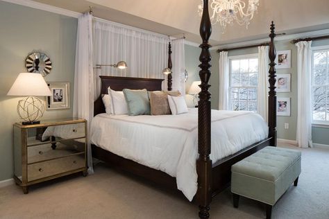 A traditional, mahogany four-poster bed adds drama to this serene bedroom. Romantic, glamorous elements, like the chandelier, mirrored nightstand and sheer curtains behind the bed, balance the dark wood bed frame. Dark Wood Bed Frame, Four Poster Beds, Dark Wood Bedroom, Dark Wood Bed, Poster Beds, Transitional Bedroom, Storage Inspiration, Four Poster Bed, Bedroom Images