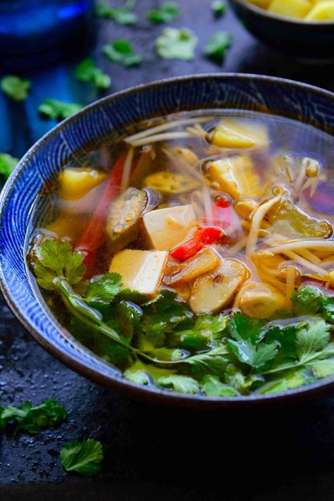 This Vietnamese sour soup recipe is ready in just 15 minutes and so full of complex flavours and textures that it just might be the most delicious bowl of soup you’ve ever tasted. This is a vegetarian version of canh chua with tamarind, pineapple, okra and silken tofu. The combination seems weird but I’m sure it will quickly become your new favourite soup! Tamarind Soup Recipes, Polynesian Dishes, Sour Soup Recipe, Vietnamese Dishes, Canh Chua, Vietnamese Soup, Okra Recipes, Vegetarian Soup Recipes, Viet Food