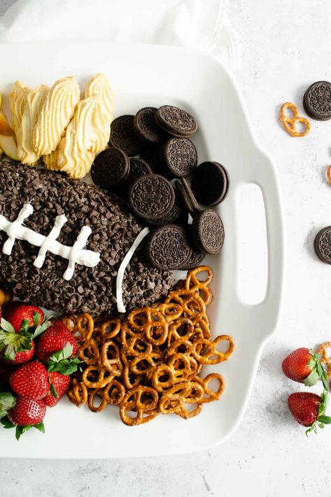 Score a touchdown with this easy and fun Football Cookies & Cream Cheesecake Dip for your next Game Day party and get ready to receive rave reviews! Whether you are there for the actual game or just for the half-time show and commercials, this simple dessert dip with Oreo cookies and mini chocolate chips can be made in 15 minutes and is sure to please! #dessert #dip #cheesecake #Oreo #cookiesandcream #gameday #football #chocolatechips #easy #snack #board Superbowl Party Dessert Ideas, Football Cheesecake, Super Bowl Charcuterie Board, Super Bowl Charcuterie, Superbowl Ideas, Football Desserts, Superbowl Desserts, Snack Boards, Superbowl Food