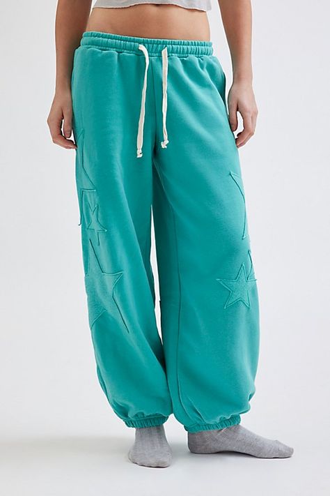 Ulta-cozy Out From Under sweatpant in a relaxed jogger style. Designed in a fleeced knit featuring a low-rise elasticated waist with drawstring detail, relaxed leg fit that cinches at the ankle and topped with star patches down the front & back of the legs. Only at Urban Outfitters. Features Out From Under Brenda star patch jogger sweatpant Slouchy lounge pant Super soft knit Low-rise elasticated waistline with drawstring tie Side pockets Star patches down the front & back of the legs Cinched el Teal Sweatpants Outfit, Jogger Set Outfits Women, Sweatpants Design, Nike Winter Jackets, Comfy Ootd, Graphic Sweatpants, Star Patches, Cute Sweatpants, Clothing Wishlist