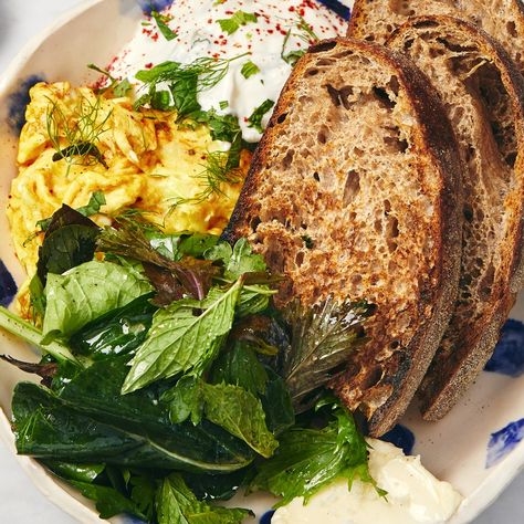 We can’t call these just scrambled eggs. At Ochre Bakery in Detroit, No. 4 on our 2019 Hot Ten list, they soft scramble eggs with turmeric and serve them with tzatziki; a big pile of greens; a very generous serving of very good butter; two holey slices of country bread; and a tiny bowl of cumin seeds, Aleppo-style pepper, and flaky sea salt. A quick word to the wise: Preground curry powder can go musty quickly. If your jar isn’t fresh, replace it for the sake of these buttery, fast-scrambled ... Vegan Pistachio Cake, Spiced Eggs, Bon Appetit Recipes, Chocolate Hazelnut Cookies, Pecan Muffins, Creamed Cucumbers, Tzatziki Recipes, Country Bread, Cafe Concept