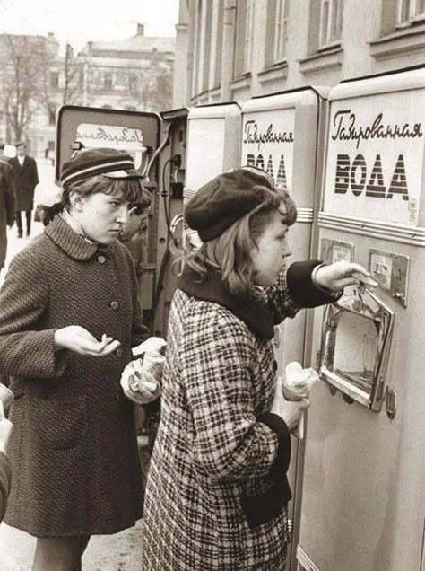 Young people buying a soda drink at the soda vending machine. Mixed sweet syrup, with sparkling water. Back in the USSR. 60's. Vintage photo. Soviet Union Aesthetic, Union Aesthetic, Soda Vending Machine, Ww2 Propaganda Posters, Soviet Aesthetic, Soviet Fashion, Back In The Ussr, Soda Drink, Russian History