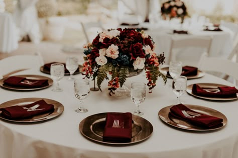 Kara and Ben incorporated beautiful burgundy details throughout their day. Their reception tables featured ivory linens, burgundy napkins, gold chargers, and breathtaking florals designed by a family friend! Burgundy Table Linens Wedding, Wedding Table Decorations Burgundy Blush, Cream Suit Burgundy Tie, Burgundy Themed Wedding Table Settings, Burgundy Flower Table Decor, Ivory And Burgundy Wedding Table, Wedding Table Settings Burgundy, Round Burgundy Wedding Tables, Burgundy Gold Table Setting