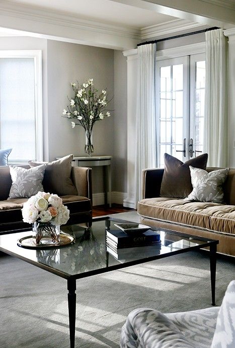 Gray and brown living room features a pair of brown velvet sofas lined with gray pillows facing an oversized glass top coffee table. Gray And Brown Living Room, Brown Velvet Sofa, Dark Brown Couch Living Room, Brown And Cream Living Room, Gray Pillows, Grey And Brown Living Room, Brown And Blue Living Room, Sage Design, Brown Sofa Living Room