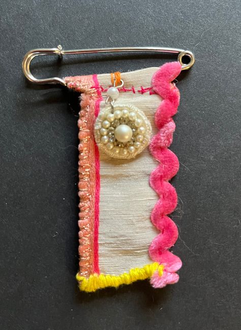 "This lapel pin, or more fun \"Zou-dle\" is made from some a gorgeous scrap of fabric. It's so pretty it's hard to part with. Parchment silk has small lines of peach and fuchsia. I added some ribbon in yellow and pink velvet.  Attaches with a \"kilt\" pin.  This is a small and subtle one-of-a-kind piece that no one else will have.  Great conversation piece. Free shipping!" Ribbon Brooch Diy, Fabric Lapel Pins Diy, Vintage Ribbon Brooches, Kilt Pin Fabric Brooches, Ribbon Chatelaine, Unique Handmade Pink Brooch, Safety Pin Art, Kilt Pin Brooches, Kilt Pin