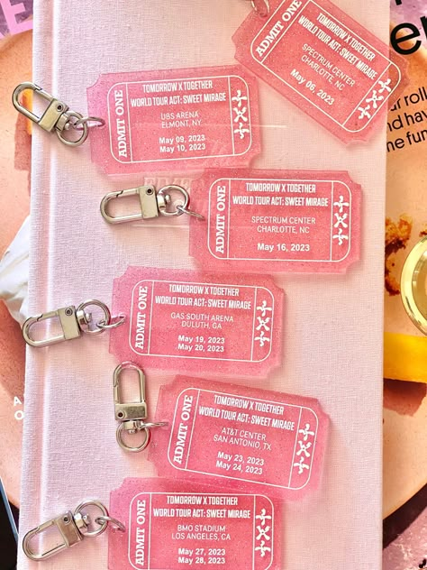 Get your hands on our limited edition Tomorrow Together concert tour keychain and show your love for one of your favs! Made with high-quality pink transparent glitter acrylic, this keychain features a stylish ticket design that matches their  concert theme colors. This keychain is the perfect accessory for any kpop fan, and it's a great way to commemorate their World Tour Act Sweet Mirage. It's also a great addition to any collection of kpop merchandise, and it's sure to be a conversation starter among your fellow Kpop enthusiasts. Order your concert tour keychain today while supplies last! Don't miss out on this opportunity to own a piece of history and show your support for the boys! Concert Merchandise Ideas, Kpop Concert Ticket, Keychain Merchandise, Kpop Concert Freebies, Merchandise Ideas Products, Kpop Packaging, Concert Freebies, Concert Accessories, Concert Theme