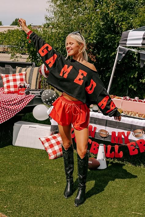 - Gear up for game day with this trendy crop sweatshirt! It's the perfect piece for cheering on your team or adding a sporty chic vibe to your casual wardrobe. - Unlined lightweight sweatshirt material with unfinished frayed seam accents - 'GAME DAY' lettering across the sleeves and front - A boat cut neckline - Long sleeves with ribbed cuffs - An ultra relaxed silhouette that ends in a cropped hemline - This piece is perfect for fans of Arkansas, Georgia, Texas Tech, Alabama, Oklahoma, and more Black And White Gameday Outfits, Kc Chiefs Outfit Ideas Women, A&m Gameday Outfit, Nfl Wife Outfits Black Women, Hockey Outfits For Women, University Of Alabama Game Day Outfits, Gameday Photoshoot, Winter Football Game Outfit Cold Weather, Winter Game Day Outfit