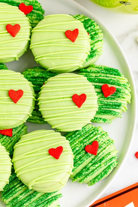 These Grinch chocolate covered Oreos put a fun Christmas twist on a classic treat. These cute and colorful Christmas cookies are an adorable and delicious addition to your holiday celebrations. Cute Christmas Desserts Grinch, Winter Chocolate Covered Oreos, Cute Desserts Christmas, Green Christmas Treats, Cute Christmas Cookies For Kids, White Chocolate Covered Oreos Christmas, Dessert Christmas Gifts, Grinch Oreo Cookies, Choc Covered Oreos Christmas