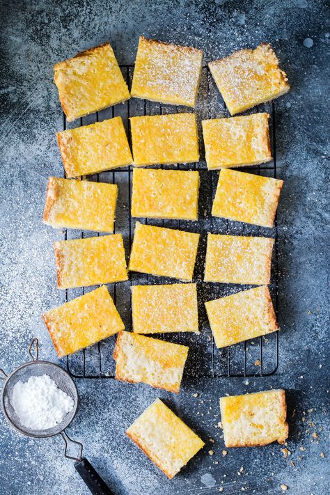 A rich filling made with fresh oranges, sugar, and eggs and then baked in a buttery shortbread style crust. These orange bars are the perfect treat to have with a cup of your favorite coffee! #baking #lemonbars #orangebars