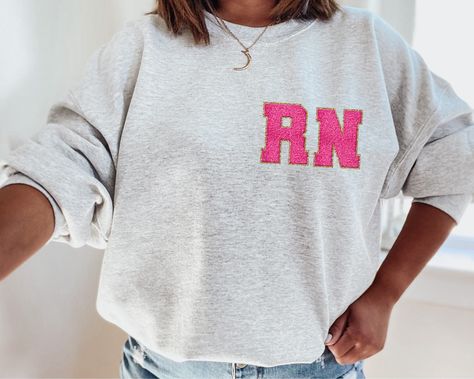 RN Patch Sweatshirt Crewneck #etsy shop: Chenille Varsity Letter RN Sweatshirt, Registered Nurse Shirt, RN Nurse Shirt, RN Shirt, Nurse Graduate Gift, Cute Nurse Shirt, Nurse Gift https://etsy.me/3Wdw7hr #graduation #black #bohohippie #shortsleeve #phrase Esthetician Gifts, Michigan Sweatshirt, Coach Shirts, Coffee Sweatshirt, Gildan Sweatshirts, Nursing Shirts, Esthetician, Going To The Gym, Casual Wardrobe