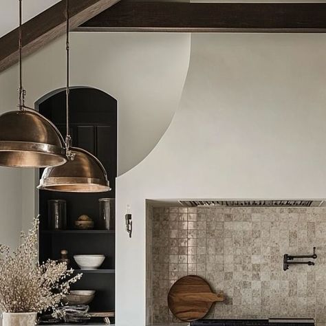 Whitechapel Real Estate Group on Instagram: "I have yet to see a kitchen that I describe as my “dream kitchen”, so I’m pulling bits & pieces of design elements from different kitchens as we put together our building plans. The features I love about this kitchen are the oversized statement vent hood (do we consider this to be Tudor style?), black inset shelving, large black frame windows, AFrame ceiling, and contrast between the light & dark elements throughout with the metallic of the light fixtures and appliances against the wood elements. I have seen a zoomed out view of this kitchen and it shows there are two islands that run perpendicular to the back wall and not sure how I feel about this just yet.  #homedesign #modernorganic “kitchendesign" Oversized Kitchen Hood, Arch Over Stove, Black Frame Windows, Frame Windows, My Dream Kitchen, Dark Elements, Kitchen Hoods, Kitchen Range, Vent Hood