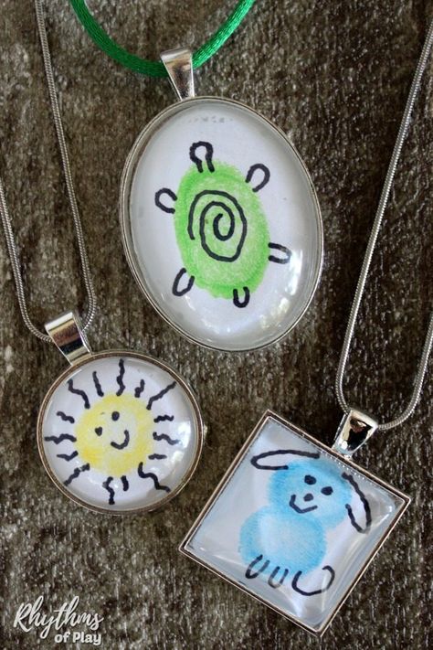 Use your fingers and thumbs to create fingerprint artwork! Then, take your creation and turn it into a necklace! DIY fingerprint art necklaces are a fun, easy & personalized craft...and they make the perfect gift! | #RhythmsOfPlay #DIYGift #HandmadeGift #JewelryMakingForKids #KidsCraft #CraftsForKids #FingerprintArt Fingerprint Artwork, Homemade Kids Gifts, Print Crafts, Thumbprint Art, Art Books For Kids, Kindergarten Craft, Fingerprint Crafts, Domino Art, Easy Homemade Gifts