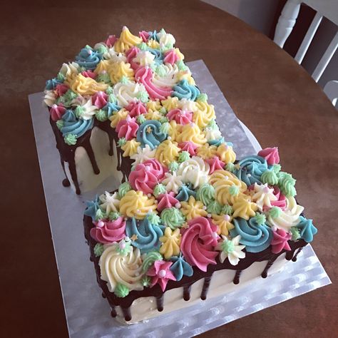 Number one shaped first birthday drip cake. Chocolate fudge with vanilla buttercream and chocolate ganache. Decorated with multi coloured piping. 1 Shape Cake, Number 1 Cookie Cake, Square Drip Cake, Number 1 Birthday Cake Girl, Colorful Number Cake, One Shaped Cake 1st Birthdays, 1 Shaped Birthday Cake, Number Cake With Sprinkles, Number 8 Cake