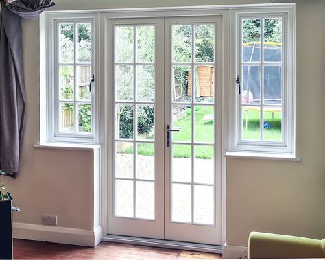 ✨Stunning hardwood French doors with sidelights and traditional Georgian bars - straight from our Orpington installation!👷‍👷‍⠀ This design can enhance not only traditional properties and renovation projects, but also can be perfect for new build homes - especially if you want to add a touch of traditional charm to your home. 😍 Georgian Bar French Doors, French Doors With Window Above, French Doors With Windows On Each Side, Patio Doors In Kitchen, Georgian Bars Window, Banquettes Seating, French Wooden Doors, Kitchen With Patio Doors, French Doors With Side Windows