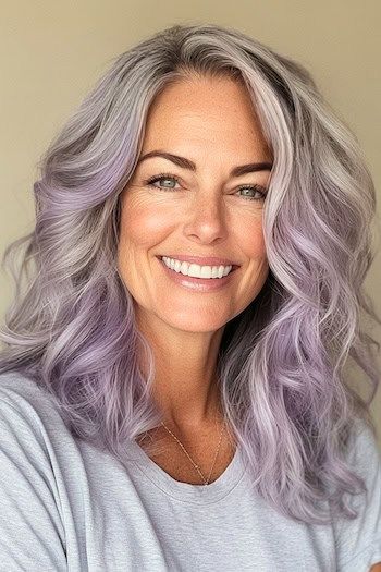 Save this pin for the best silver hair color ideas. Dreamy lavender-silver waves offer a pastel twist on gray hair. This medium-length style features soft, loose curls that catch the light gorgeously. Amythest Hair Colour, Purple Highlights On Grey Hair, Gray Hair Purple Highlights, Gray Hair With Purple Highlights, Smokey Lavender Hair, Grey Hair With Purple Highlights, Lilac Silver Hair, Lilac Grey Hair, Silver Lavender Hair