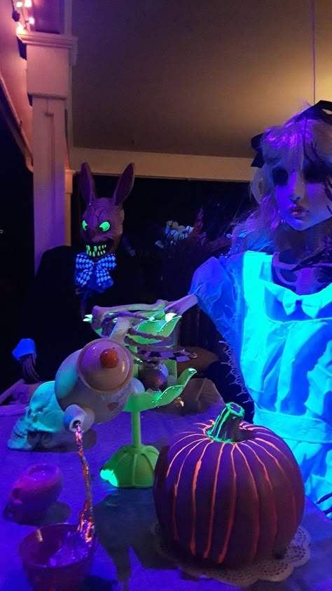 A creepy glowing Alice serves tea to a sharp-toothed March Hare. Alice In Wonderland Halloween Decor Outdoor, Alice And Wonderland Halloween Decor, Creepy Wonderland, Creepy Alice In Wonderland Art, Halloween Alice In Wonderland Party, Alice In Wonderland Haunted House Ideas, Diy Alice In Wonderland Halloween Decorations, Wonderland Halloween, Black Light Alice In Wonderland