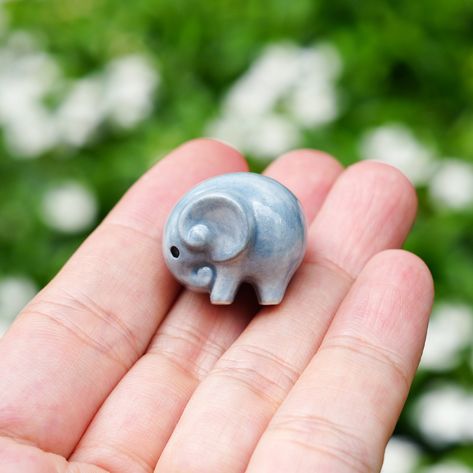 A tiny ceramic elephant figurine This elephant is crafted from fine porcelain, and meticulously hand painted in detail with great quality, highly collectible. He is the perfect for any miniature collector or elephant lover. Dimensions -- TINY GREY ELEPHANT FIGURINE: 0.7" (1.8 cm) - 0.75" (1.9 cm) -- TINY GREY ELEPHANT NECKLACE: Each charm is about 0.7" (1.8 cm) - 0.75" (1.9 cm) Chains are custom in 14 - 18 inches. -- Materials-- Pendant: Porcelain Clay, High Glaze The chain is made of high quali Elephant Clay, Elephant Ceramics, Clay Elephant, Elephant Pottery, Elephant Decoration, Tiny Elephant, Small Elephant, Miniature Figurine, Ceramic Elephant