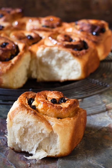 chelsea buns on a rack with one on surface in front Fruit Buns Recipe, Enriched Dough Recipes, Chelsea Buns Recipe, Sweet Brioche Buns Recipe, Chelsea Buns Recipe Easy, Chelsea Buns, Devonshire Split Buns, Quick Brioche Buns, Buns From Home London