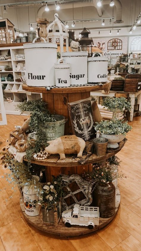 flour, tea, sugar, coffee canisters, greenery Farmhouse Store Design, Retail Set Up Display Ideas, Furniture Vendor Booth Display, General Store Display Ideas, Spring Merchandising Ideas, Spool Display Ideas, Farmhouse Store Display Ideas, Thrift Store Window Display Ideas, Rustic Booth Display Ideas