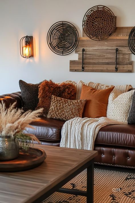 Cozy fall living room featuring a leather sofa adorned with warm-toned pillows, a textured blanket, rustic wall decor, and ambient lighting. #FallLivingRoom Living Room Aesthetics, Creative Living Room, Wall Decor Unique, Room Aesthetics, Fall Wall Decor, Autumn Inspired, Living Room Loft, Room Walls, Hobby Room