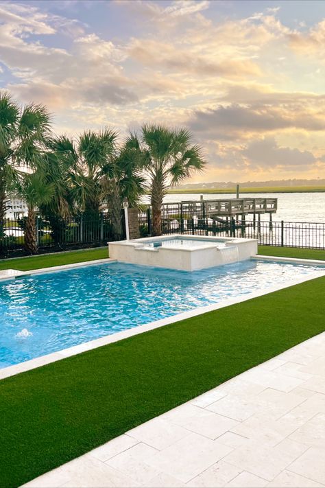 A pool surrounded by artificial turf with a body of water in the background Pools With Artificial Turf, Artificial Turf Around Pool, Pool With Turf, Pool Surrounds, Pool Inspiration, Synthetic Turf, Beautiful Pools, Artificial Turf, Ready For Fall