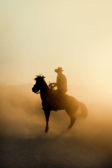 A cowboy riding a horse in the desert at sunset · Free Stock Photo Desert Cowboy, Riding A Horse, Sunset Glow, Dawn And Dusk, On Horseback, American West, Horse Pictures, Guy Pictures, In The Desert