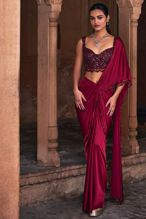 Maroon Draped Skirt Saree Set that captivates with its elegance. The eye-catching saree is crafted in tulle and armani satin with tassel details. It is paired with an embroidered blouse. For weddings or festive occasions. New Indian Fashion Finds redefine festive style with our innovative fusion designes.   #Perniaspopupshop #womenswear #ethnic #whatiworewastrending #ppuslove #sareeset #armanisatin #tulle #festivewear #sareeforwomen #printedsaree #weddingwear #skirtsaree Fusion Saree, Skirt Saree, Drape Sarees, Fusion Wear, Sharara Suits, Letters Design, Half Saree Designs, Saree Designs Party Wear, Satin Saree