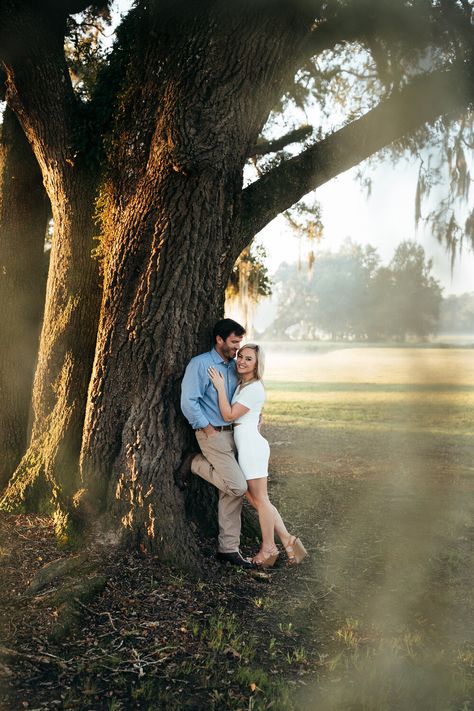 Couple Tree Photography, Couples In The Park, Engagement Pics With Trees, Couple Poses With Tree, Park Couple Photoshoot Ideas, Couple Grass Photography, Bayou Engagement Photos, Oak Tree Photoshoot, Engagement Photos Willow Tree