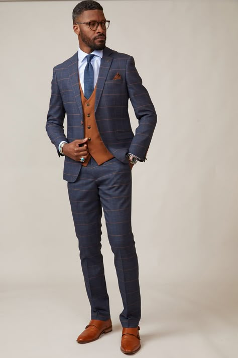 This characterful three piece is adorned in a Prince of Wales style check and will transform your work wear from dull to dapper. A popular choice for business minds or Grooms to be! Men Business Suits Style, Blue Suit Styles For Men, Blue Suit With Orange Tie, Navy And Orange Outfit, Blue And Brown Suit, Fall Wedding Mens Attire, Summer Wedding Suits Groom, Navy Suit Outfit Men, Fall Wedding Suits For Men