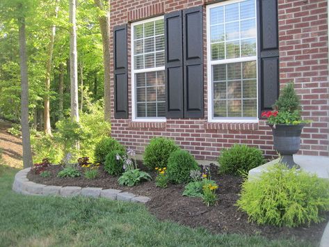 Before building this retaining wall, you could barely see our plants. Now, it gives them some height & added a little more curb appeal to the front yard. To see more & a quick version of how we created it, go to my blog http://designedtodwell.blogspot.com/2011/06/so-i-finally-convinced-my-husband-to.html Retaining Wall Curb Appeal, Boxwood And Hostas, Retaining Wall Front Of House, Wall Gardening, Concrete Retaining Walls, Landscape Outdoor, Luxury Landscaping, Landscaping Retaining Walls, Stone Planters