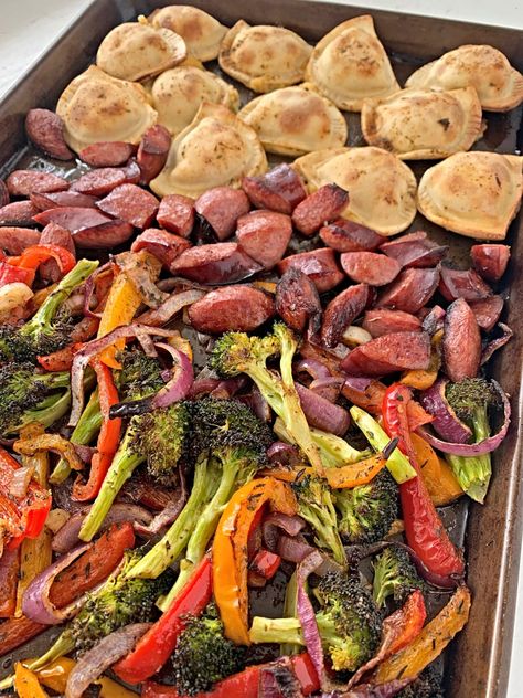 a sheet pan with roasted pierogies, sausage, peppers, and broccoli Perogies And Kielbasa Sheet Pan, Pierogies Sheet Pan, Perogies Frozen Recipes, Kielbasa And Pierogies Sheet Pan Meal, Sheet Pan Perogies And Kielbasa, Pierogies And Kielbasa Sheet Pan, Perogies Sheet Pan, Pierogies And Broccoli, Pierogi Kielbasa