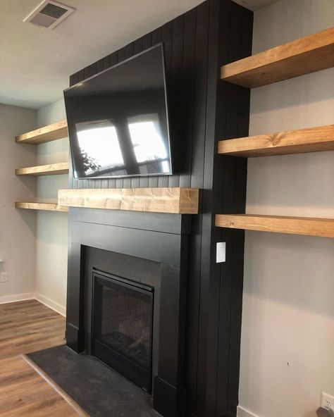 Black Modern Electric Fireplace, Tv Hanging From Ceiling Living Room, Black Fireplace With Shelves On Side, Black Fireplace With Floating Shelves, Black Fireplace Floating Shelves, Black Living Room Fireplace, Black Accented Living Room, Diy Fireplace And Shelves, Black Painted Fireplace Wall