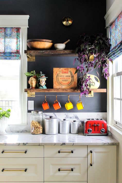 Love the rustic wood shelves against the black painted walls in this white kitchen kellyelko.com #bohodecor #vintagedecor #kitchendecor #kitchens #openshelves