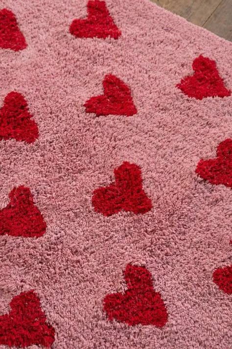 Our Agatha rug is bright and playful with red hearts on a pink background. This rug has been made using recycled cotton fabric, tufted for that gorgeous texture. Each end of this rug has a blue and white chequered border finished with a knotted fringe.  A cute addition to smaller spaces, cosy nooks, or beside a bed. Wherever this little rug goes, it will make your smile. Pink And Red Apartment, Pink And Red Rug, Pink And Red Room Decor, Red And Pink Decor, Pink And Red Room, Red And Pink Bedroom, Pink And Red Bedroom, Heart Room Decor, Lover Bedroom